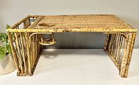 Side view of the vintage breakfast lap tray showing rattan frame and woven wicker top with cup holder cutout