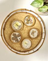 Top view of round wicker tray with five butterfly coasters inside