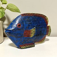 Side angle showing detailed paintwork and carved features of the blue tropical fish sculpture.