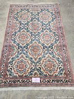 Full view of Persian wool rug laid flat on concrete floor
