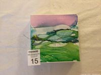 Front view of the original alcohol ink painting on Yupo paper featuring an abstract landscape in greens, blues, and purples, signed by the artist.