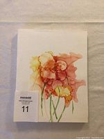Photo of original alcohol ink artwork titled 'Early Spring Bouquet' showing a mounted floral abstract composition in red, orange, yellow, and green on white Yupo paper.