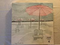 Photo of the watercolor painting showing pink umbrellas on a snowy beach with Adirondack chairs and winter scenery, mounted on birch board.