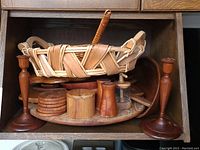Photo of shelf with wooden basket, coasters, candlesticks, shakers, bowl, and lazy susan with all items grouped together