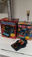Zaxxon and Donkey Kong retail boxes with Wildfire handheld game in front