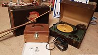 Full view of lot showing Westinghouse record player in open suitcase, two suitcases, walking stick, iron, and measuring stick on floor.