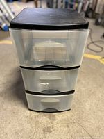 Front view of the plastic storage tower with three translucent drawers and black top.