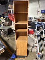 Full front view of the wooden rotating display cabinet showing shelves and lower cabinet door.