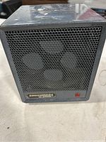 Front view of the small ceramic heater showing the honeycomb metal grille and power indicator light with Pelonis branding.