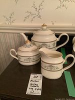 Full view of three pieces: teapot, sugar bowl, creamer, all showing Henley pattern and gold trim