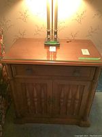 Front view of wooden record cabinet with drawer and two-door lower storage under glass top