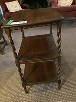 Full front angle of the oak side table showing top and two shelves, barley twist legs, and decorative beading.