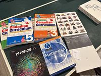 Top view showing books for Canadian curriculum, Physics 11, Mathematics, Lego book, and unopened stretched canvas package