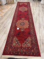 Carpet runner fully unrolled showing detailed patterns and overall size on wood floor.