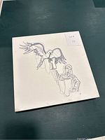 Photo of the original Central Asian art on canvas showing a human figure with geometric pattern clothing holding a bird with outstretched wings in black ink on white canvas.