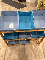 Top view showing three fabric boxes on top shelf in blue tones, middle and bottom shelves visible with additional fabric bins.