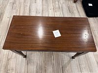 Top view of rectangular wooden table with smooth brown finish and some surface wear.