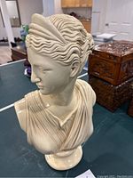 Angled side view showing the detailed hair waves and facial profile of the bust.