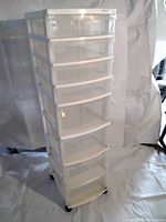 Full view of tall 8-drawer plastic rolling storage unit with translucent drawers and white frame.