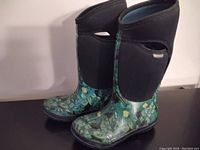 Front and side view of the pair of Bogs boots showing green and blue floral print with black neoprene upper and light blue interior lining.