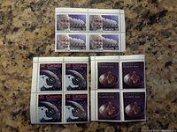 Top view showing three sets of four-panel Canadian stamps of different designs including elderly man portrait and copper spinning top, all unused