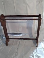 Front view of the pine quilt stand showing turned wooden rods and side panels.