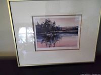 Framed signed print titled "Rising" by Brent Heighton showing full framed artwork with white matting and gold frame.