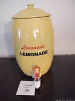Front view of the yellow ceramic lemonade dispenser with lid and spigot showing 'Limonade LEMONADE' text.