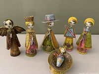 Front view of all six papier-mâché nativity figures arranged in a row showing detailed hand-painted faces and costumes.