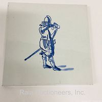 Front of the Delft tile showing detailed blue soldier figure playing a horn, painted with blue tonal variations.