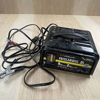 Schumacher SE 82-6 battery charger showing front view and attached cables with clamps