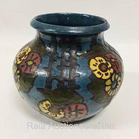 Side view of the squat vase showing colorful floral and geometric decorations on a blue background.