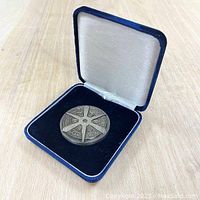 Kyoto medal displayed inside open blue velvet presentation box with white satin interior lid.