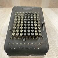 Front view of the manual comptometer showing keys, lever, and totalizer windows.