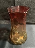Front view showing Ruby-to-Amber gradient, five-sided top and textured coin/thumbprint pattern on lower body.
