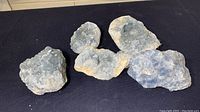 Five natural geodes arranged together, showing rough exterior and crystalline interiors.