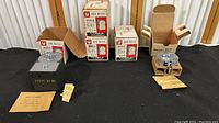 Full display of five vintage coin meters with packaging and instruction sheets on black surface.
