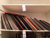 Shelf with many vinyl LP albums leaning sideways, various covers and titles visible, mostly soundtracks and orchestral albums