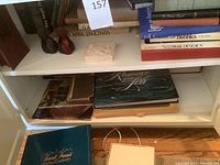 Shelf showing art books including large Gauguin and Vincent van Gogh books, and a small decorative sculpted block.