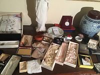 Top view of entire collection displayed on table including necklaces, bangles, watches, pen, decorative items