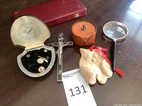 Overview of all items including Krementz jewelry box, crucifix, travel clock case, owl ornament, magnifying glass