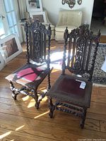 Pair of carved wooden high-back chairs in room setting