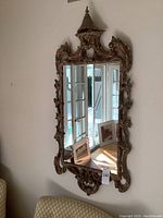 Full view of the wood framed mirror hanging on wall