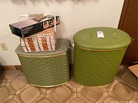 Two vintage green laundry hampers with textured pattern and a vintage sewing kit box on top