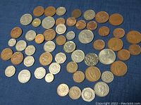 A collection of over 50 English collectible coins of various denominations, mostly copper and silver-colored with diverse designs.