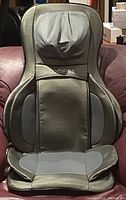Front view of COMFIER chair massager pad with padded neck and backrest areas, COMFIER logo in middle, dark gray synthetic leather upholstery.