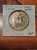 Obverse side of the 1957 South Africa half penny showing the sailing ship design and year 1957.