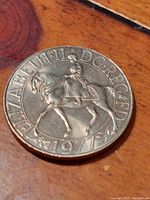 Close-up photo of the 1977 25 New Pence coin showing the obverse side with Queen Elizabeth II on horseback and inscriptions.