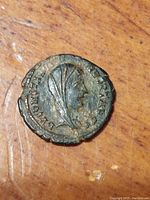 Obverse side of the ancient Roman coin depicting a veiled female bust with Latin inscriptions around the edge. Coin surface shows age wear and patina.