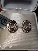 Photo of the pair of sterling silver stud earrings set with bezel rose cut Polki diamonds shown in a jewelry box, showcasing earrings design and condition.